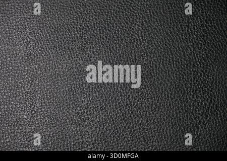 A close-up, full-frame texture of dark, pebbled or grained leather. A uniform surface suitable as a background or overlay. Stock Photo