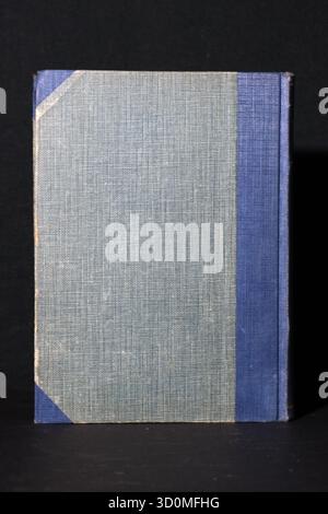Hardcover books bound in contrasting two-tone cloth (navy blue/light blue) or plain grey-blue cloth. Focus is on the fabric texture and sim Stock Photo