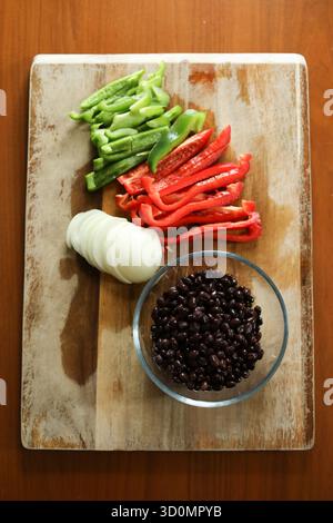 Freshly cut red and green peppers, onions, and black beans Stock Photo