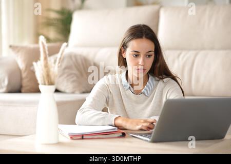Concentrated student learning online using laptop at home Stock Photo