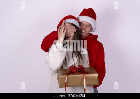 The man is surprising the woman with a Christmas gift  Stock Photo