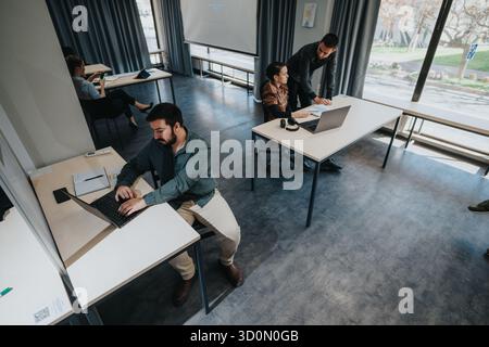 Team collaborating and working on projects in a modern office setting Stock Photo