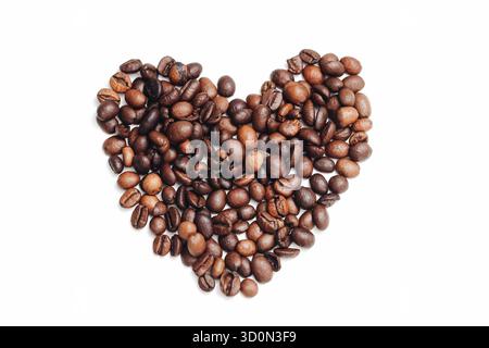 Coffee beans heart shape. Roasted arabica beans. Brown beans on white. Love coffee concept. Cafe background mockup. Minimal food flat lay. Stock Photo