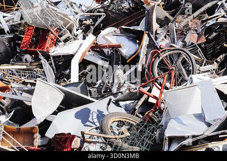 Scrap metal pile at recycling yard closeup. Mixed electronic waste and old appliances. Industrial junk background showing metal parts. Stock Photo