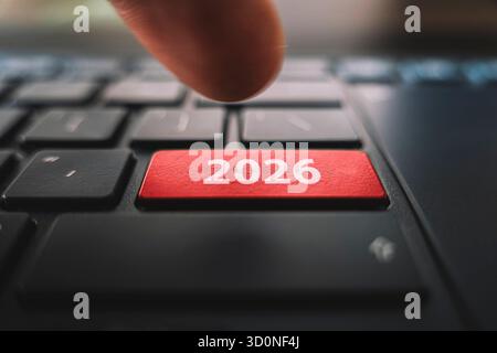 Keyboard with text 2026 year and finger pushing the enter button. Red Color button on the black keyboard of modern ultrabook. caption on the button. Stock Photo