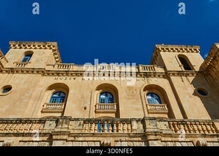Historic Limestone Maritime Museum Building in Malta With Arched Windows And Balustrades Under Clear Blue Sky Stock Photo