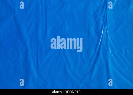 Bright blue plastic wrap sheet surface with creases and folds background Stock Photo