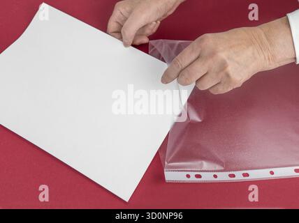 Put your document in the plastic sleeve. Saving and protection concept Stock Photo