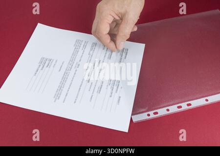 Put your document in the plastic sleeve. Saving and protection concept Stock Photo