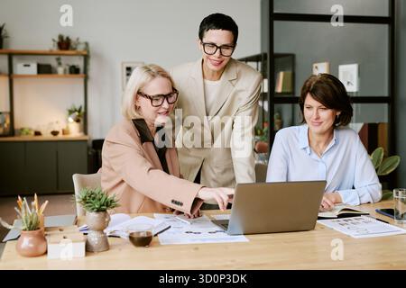 Three Middle Aged Women Collaborating on Business Project Indoors Stock Photo