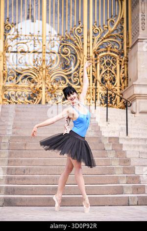 Ballet dancer posing in front of the iconic golden gates of Petit Palais in Paris. Editorial use only due to recognizable architecture. Captured on a sunny summer day in June 2025. || Model released Stock Photo