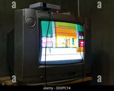 Denpasar, Bali, Indonesia – October 23, 2025: playing a retro video game on a cathode ray tube (CRT) boxy television Stock Photo