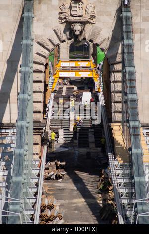 Reconstruction work on the Széchenyi Chain Bridge in Budapest, Hungary, with cranes and workers restoring the historic structure. Stock Photo