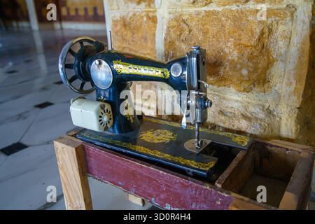 Luxor, Egypt - January 18, 2025: A vintage black sewing machine with gold detailing and a small electric motor, displayed as a decorative item inside Stock Photo