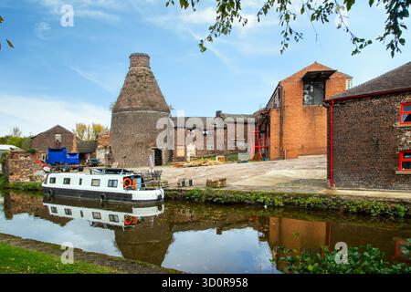 Canal narrowboat on the Trent and Mersey canal passing the old bottle kiln at the former Kensington & Price pottery works in Longport Stoke on Trent Stock Photo
