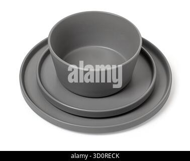 Stacked gray ceramic plate, bowl, and side plate creating a modern dining set Stock Photo