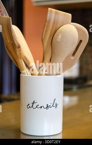 Wooden kitchen utensils spoon ladel spatula in porcelain container Stock Photo