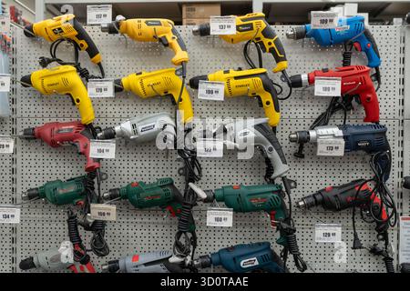 Electric drills and rotary hammers of various brands on display in the power tool store. Minsk, Belarus - july 5, 2025 Stock Photo