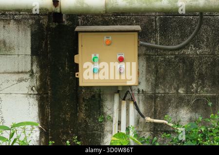 Close-up wall-mounted load center with push button installed in garden Stock Photo