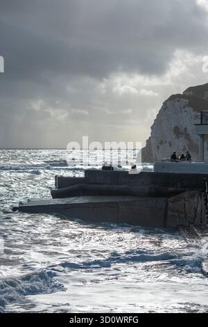 stormy weather sunset over the beach and cliffs at Freshwater Bay on the coastline of the isle of wight UK. rough sea and waves in autumn storm IOW. Stock Photo