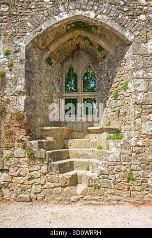 Large recessed window in wall of old medieval english castle ruins with steps and seating in frame showing anglo-saxon design style detail Stock Photo