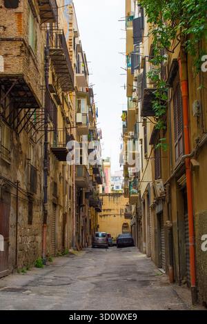 A narrow dead-end street in the Ruggero Settimo district of Palermo in Sicily, Italy. Tall multi-storey 18th-19th century apartment buildings Stock Photo