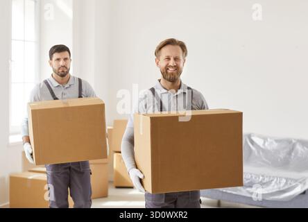 Professional movers carrying cardboard boxes during home relocation delivery service Stock Photo