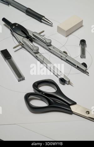 compass and scissors on white sheet of paper Stock Photo
