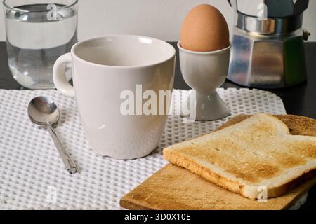cup of coffee, egg and toast on black furniture Stock Photo