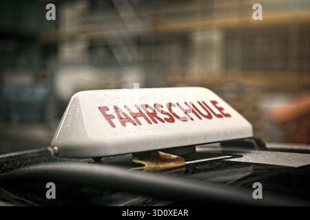 German driving school car roof sign in autumn weather. Stock Photo