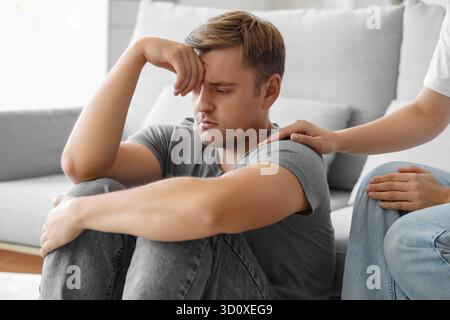 Young woman supporting man with suicidal thoughts at home Stock Photo