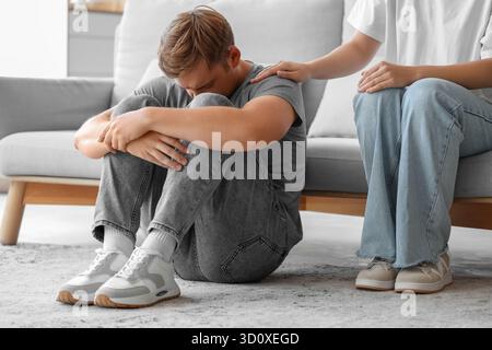 Young woman supporting man with suicidal thoughts at home Stock Photo