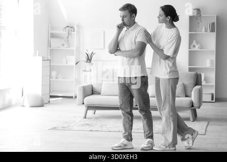 Young woman supporting sad man with suicidal thoughts at home Stock Photo