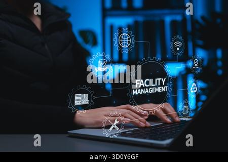 Professional using digital facility management system on laptop, representing smart building maintenance, infrastructure operations, sustainability, Stock Photo