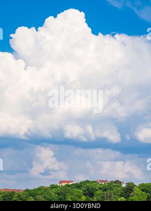 Bright clouds float above colorful residential houses in Gothenburg, creating a picturesque scene on a sunny day. The sky is clear, adding charm to th Stock Photo