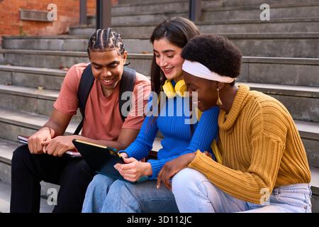 Diverse students studying together using digital tablet Stock Photo