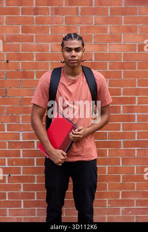 Young student with backpack holding books Stock Photo