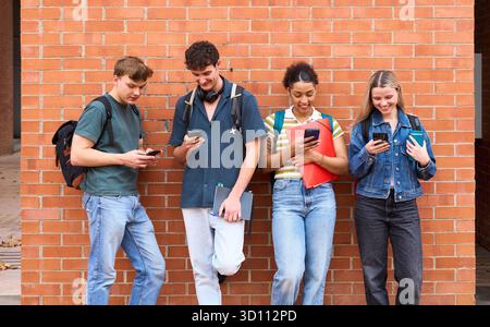 University students connecting with smartphones on campus Stock Photo