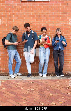 University students using mobile phones on campus Stock Photo
