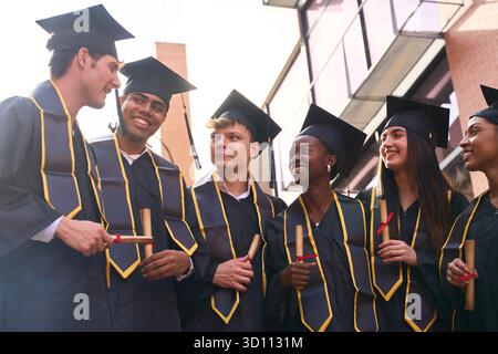 Diverse students celebrating graduation, holding their diplomas Stock Photo