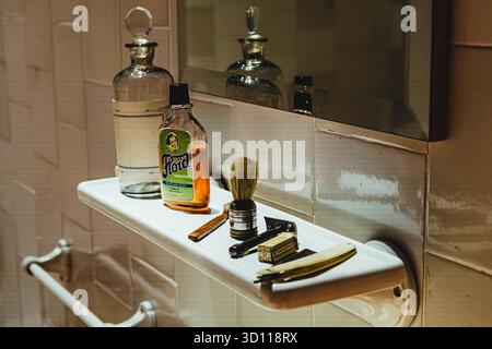 Retro men's grooming tools, aftershave and glass bottles arranged on a bathroom shelf, depicting old fashioned hygiene Stock Photo