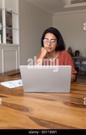 Thoughtful freelance manager woman in elegant glasses working at home Stock Photo