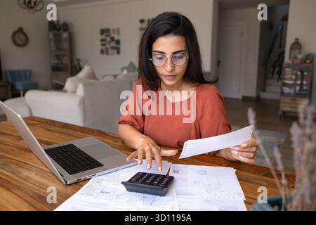 Focused young Latin freelance accountant working at home Stock Photo
