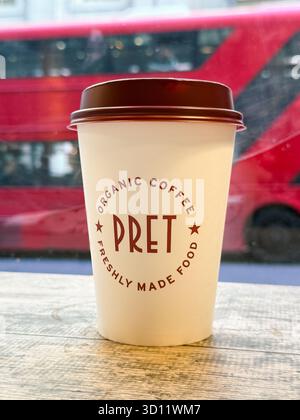 London, UK - August 20, 2025; Coffee cup with Pret brand at Pret a Manger coffee shop with out of focus London bus Stock Photo
