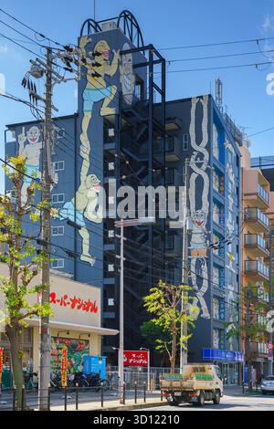 Osaka, Japan - Oct 11 2025, vertical view of the Osaka bay wheel apartments, the facade is decorated with drawings of people, without people, at dayti Stock Photo