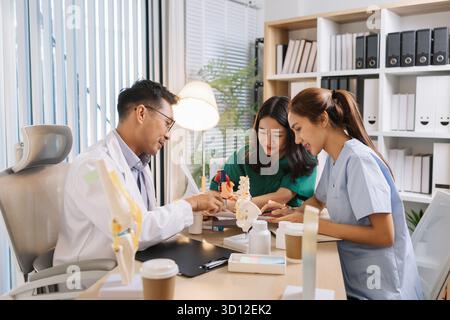 Team of doctors and nurses collaborating in a clinical environment, reviewing treatment options and sharing medical opinions to provide effective pati Stock Photo