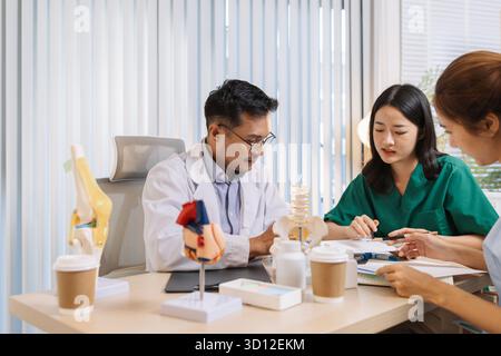 Team of doctors and nurses collaborating in a clinical environment, reviewing treatment options and sharing medical opinions to provide effective pati Stock Photo