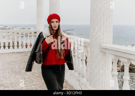 Woman fashion balcony, stylish woman posing on a festive balcony by the sea. Stock Photo