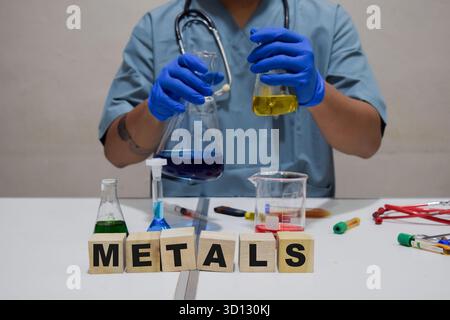 A scientist conducts experiment using test tube metals in a lab. scientific research concept Stock Photo