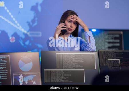 Concerned analyst monitoring cybersecurity incidents in SOC environment on multiple screens Stock Photo